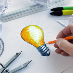 Designer drawing a light bulb, concept for brainstorming and ins